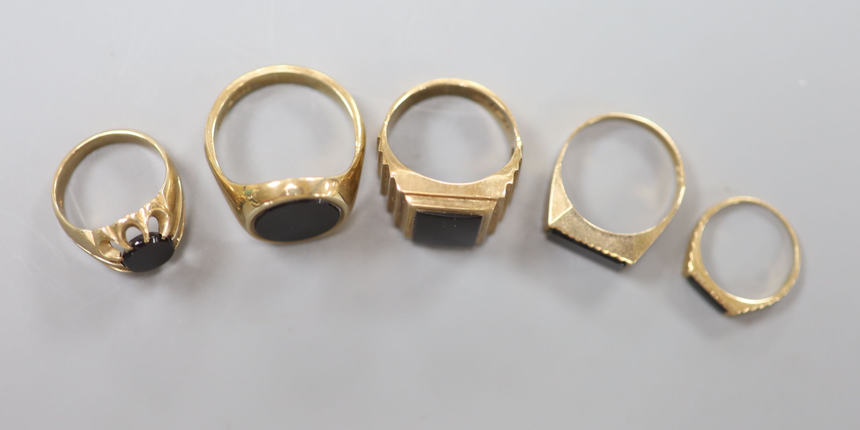 Three assorted 9ct and black onyx signet rings and two other similar rings, largest size W